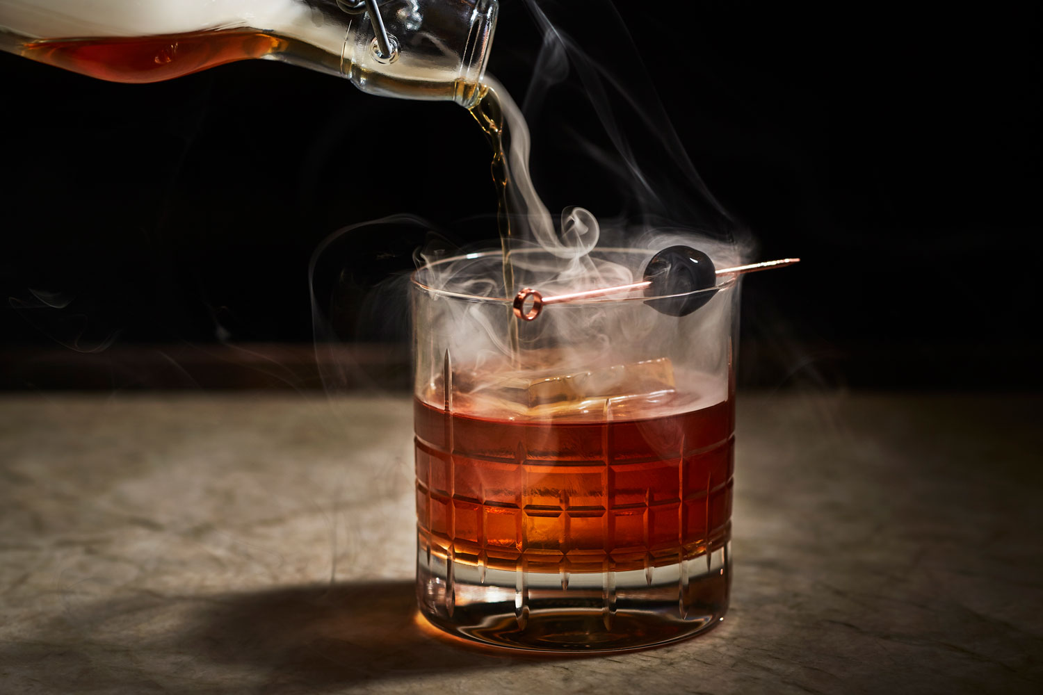 bartender pouring cocktail into glass